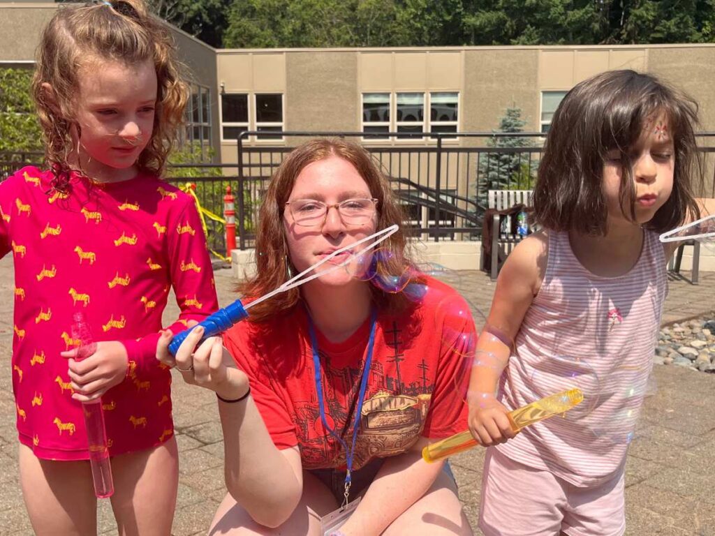 Counselor and campers blowing bubbles