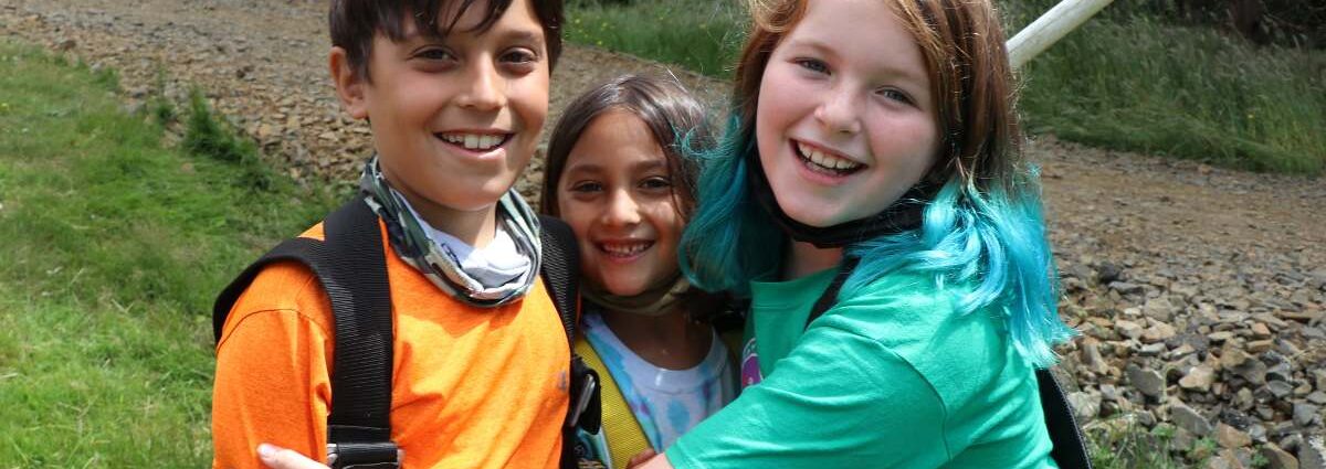 Three young campers hugging