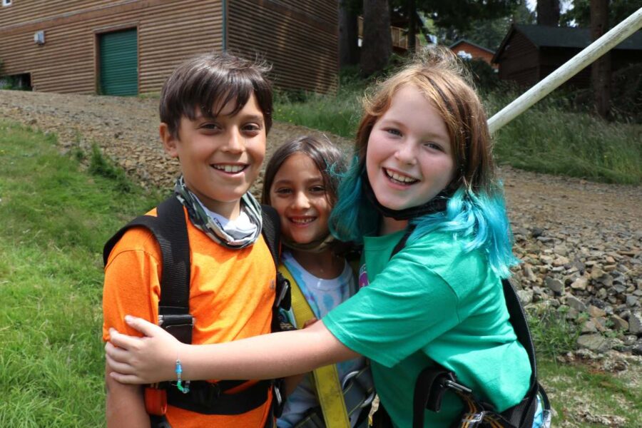 Three young campers hugging